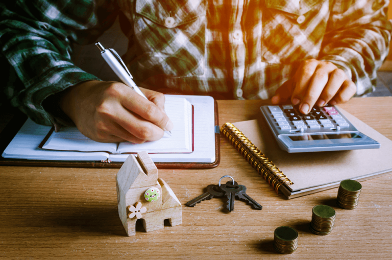 Um homem calculando a melhor opção para compra de um imóvel. Consórcio ou Financiamento